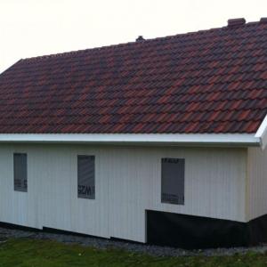Tak med rødlig takstein, på baksiden av garasjen.